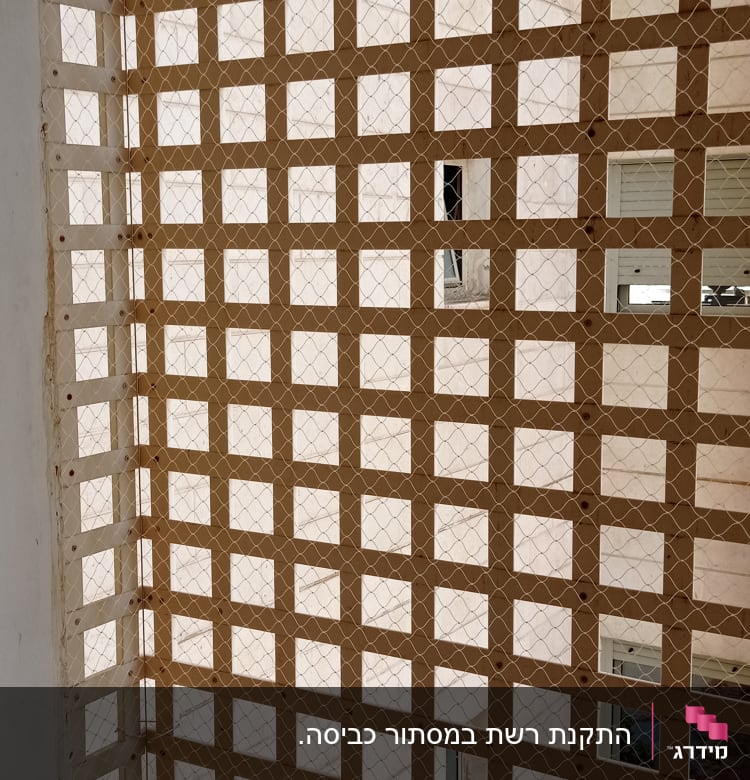 רשת מתכת מותקנת על חלון למניעת כניסת יונים